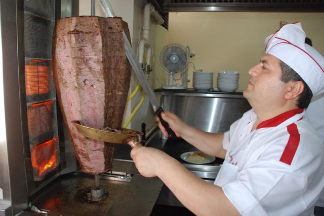 Sıcak havada döner kesen ustalar vantilatörle serinliyor